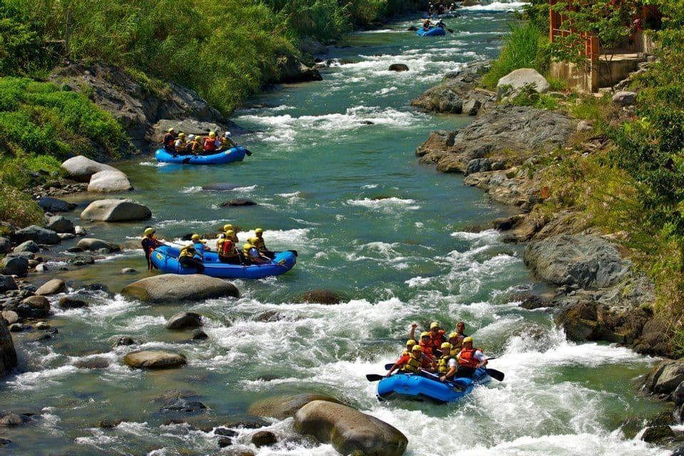 Un viaggio di gruppo WeRoad per fare rafting su tre gommoni blu lungo un fiume impetuoso, tra sponde rigogliose e rocciose.