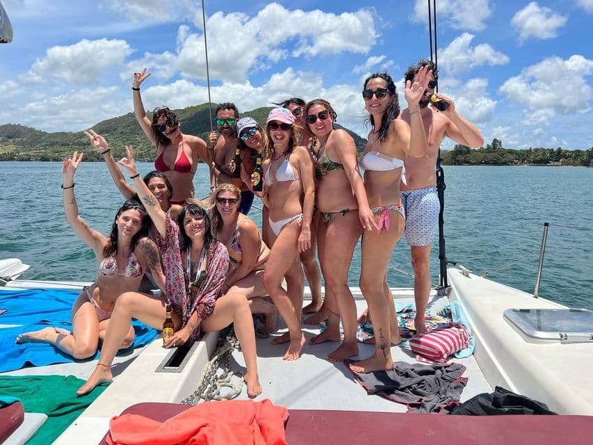 Viaggio di gruppo WeRoad: sorrisi e pose in costume da bagno sul ponte di una barca a vela in una giornata di sole.