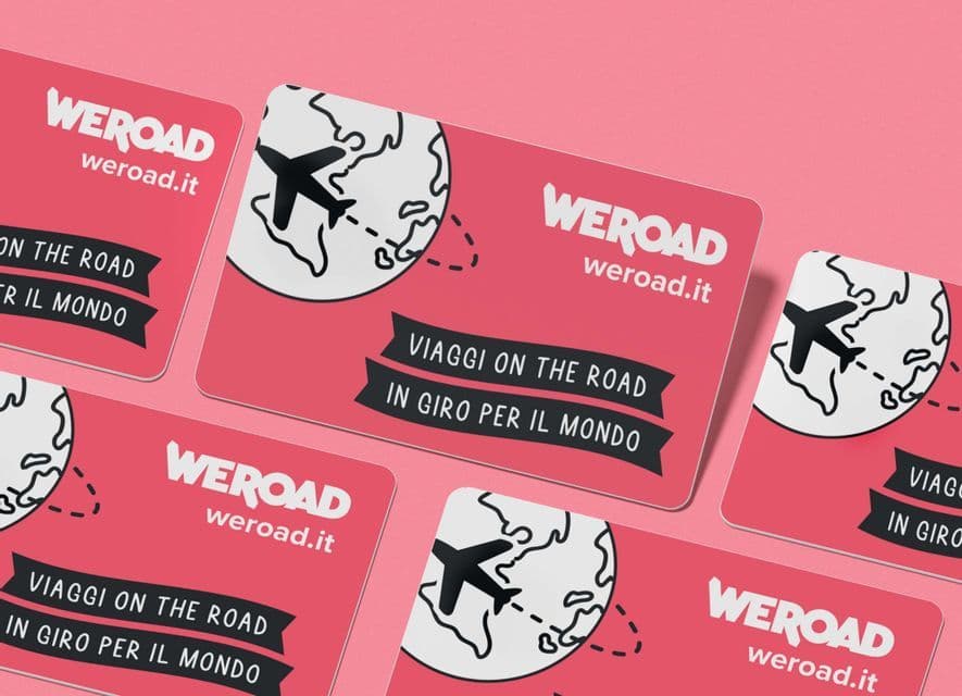 Un insieme di carte rosa a marchio WeRoad con un logo, un mappamondo e una grafica di aeroplano su uno sfondo rosa coordinato.