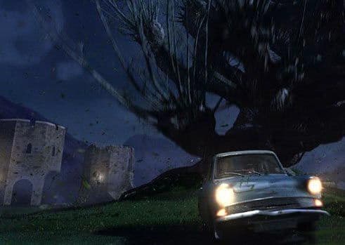 Un árbol grande con ramas que azotan ataca un coche azul antiguo por la noche, con un castillo de fondo.