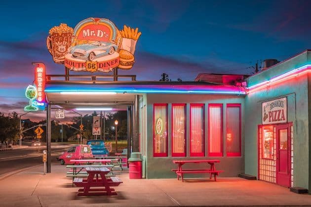 Das Äußere von Mr. D'z, einem Retro-Diner an der Route 66, erstrahlt in der Dämmerung mit farbenfrohen Neonschildern.
