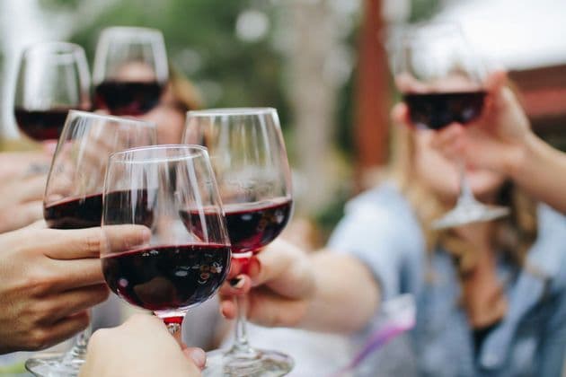Un gruppo WeRoad che brinda con calici di vino rosso.
