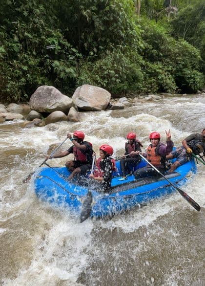 Un groupe WeRoad en casques rouges descend une rivière en rapides sur un radeau bleu.