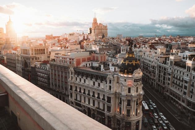 Una vista rialzata dell'architettura e delle strade storiche della città con traffico durante l'ora d'oro.