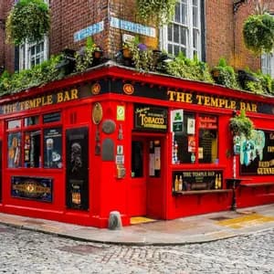 The bright red facade of The Temple Bar, a corner pub on a cobblestone street, adorned with lush hanging green plants.