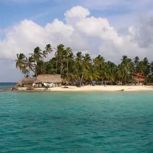 Une petite île tropicale avec des palmiers et des cabanes sur une plage de sable blanc, entourée d'eaux turquoise sous un ciel nuageux.