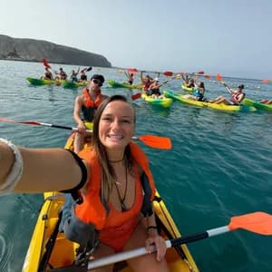 Una donna si scatta un selfie dal suo kayak durante un viaggio di gruppo WeRoad in mare, con altri kayakisti sullo sfondo.