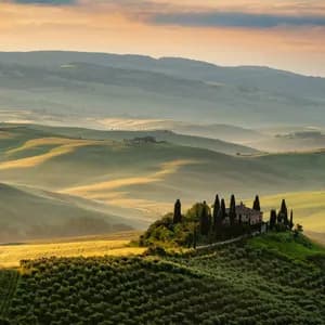 Una villa in pietra circondata da cipressi si erge su una collina che domina un paesaggio di dolci colline verdi all'alba.