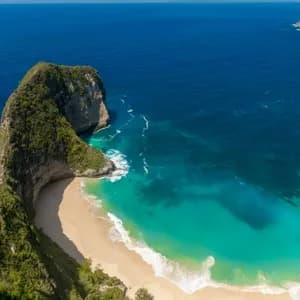 Eine Luftaufnahme einer grün bewachsenen Klippenformation, die in einen tiefblauen Ozean ragt und einen abgelegenen weißen Sandstrand mit türkisfarbenem Wasser bildet.