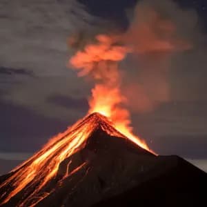 A volcano erupts at night, with glowing lava flowing down its dark slopes under a starry sky.
