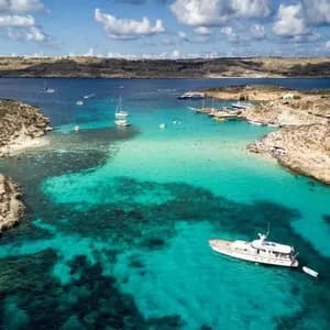 Vista panoramica del mare di malta con scogli e barche