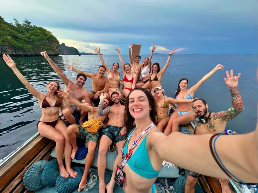 Una donna si fa un selfie sorridente del suo viaggio di gruppo WeRoad mentre posano su una barca di legno in mare.