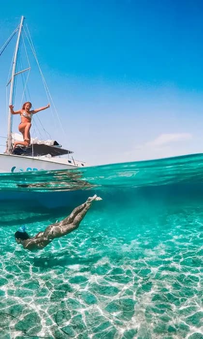 Una toma doble de un viaje en grupo de WeRoad, con una mujer en un velero y otra nadando bajo el agua en aguas claras y turquesas.
