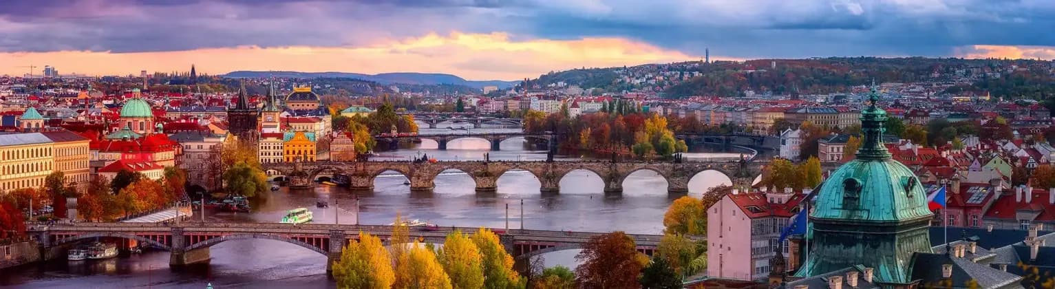 The bridges of Prague over the Vltava river surrounded by autumn colours.