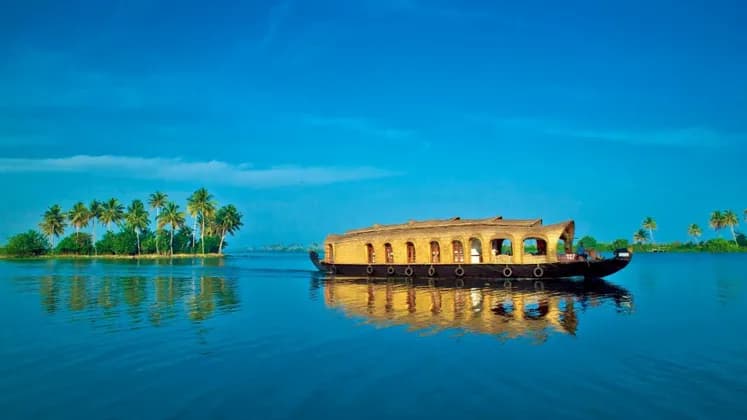 Ein traditionelles Holzhausboot mit Reetdach schwimmt auf ruhigem blauem Wasser, mit Palmen an einem fernen Ufer.