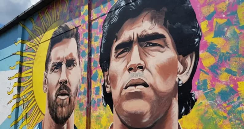 Murale di street art colorato con ritratti dei calciatori argentini Lionel Messi e Diego Maradona.