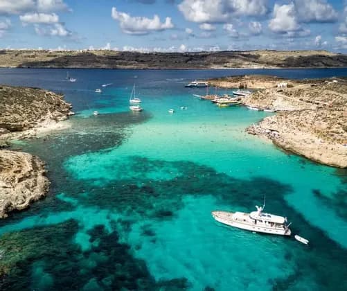 Vista panoramica del mare di malta con scogli e barche