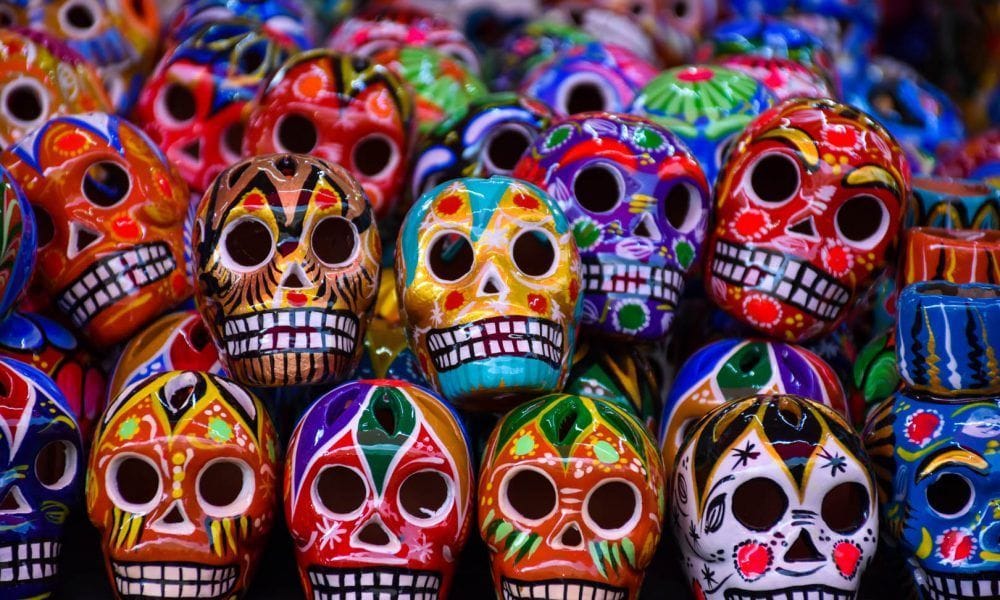 Primer plano de un gran montón de calaveras coloridas, que son calaveras decorativas de la tradición mexicana.