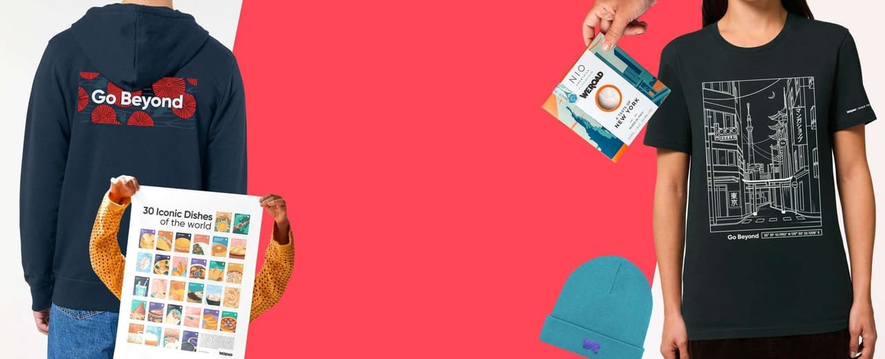 Una composizione flat lay di prodotti WeRoad, con felpa, maglietta, berretto, poster e cocktail box, su sfondo rosso.