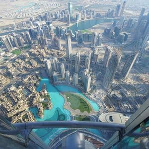 Une vue panoramique en plongée d'une ville moderne avec de nombreux gratte-ciel et des voies navigables turquoise, vue depuis une terrasse d'observation.