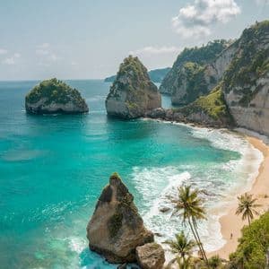 Veduta dall'alto di una baia tropicale con acqua turchese, spiaggia sabbiosa e grandi faraglioni, circondata da alte scogliere.