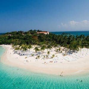 Vista aerea di un'isola tropicale con spiaggia di sabbia bianca, palme e persone che nuotano in acque cristalline color turchese.