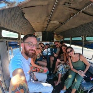 Un viaje en grupo de WeRoad con gente sonriente se toma una selfie dentro de un vehículo de transporte local.