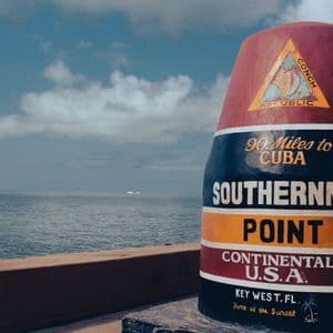 La bouée du point le plus au sud de Key West, Floride, se dresse au bord de l'océan sous un ciel nuageux.