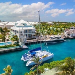 Sailboats moored in a turquoise harbor in the Bahamas