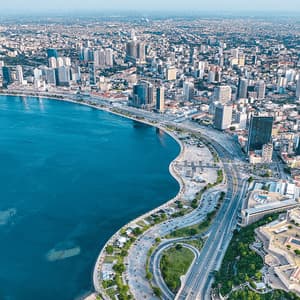Una vista aerea di una densa città costiera con una baia curva e una storica fortezza a forma di stella che domina il lungomare.
