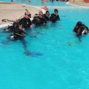 Un viaggio di gruppo WeRoad impara ad immergersi con un istruttore in piscina.