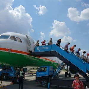 Un viaggio di gruppo WeRoad con persone che sbarcano da un aereo sulla pista tramite una scala mobile.