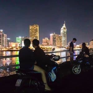 Saigon by scooter at night A scooter above the Ho Chi Minh City skyline at night