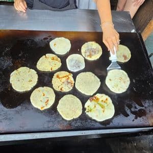 Pupusas cooking on a hot comal, the national dish of El Salvador