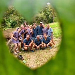 Un viaggio di gruppo WeRoad con tuniche stampate abbinate, in posa all'aperto incorniciati da un foro a forma di cuore in una foglia.