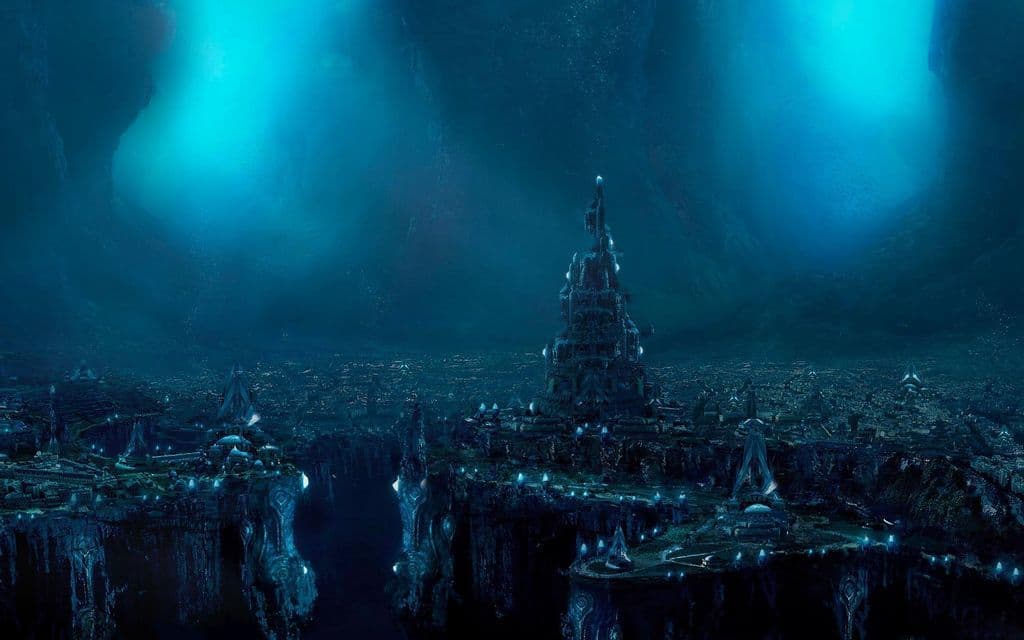 Una vasta città sottomarina futuristica con edifici blu luminosi e una torre centrale costruita su un altopiano roccioso.