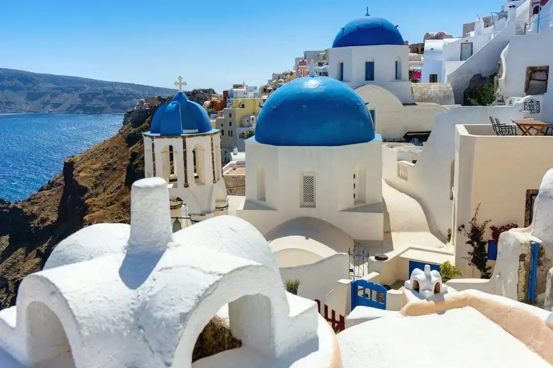 Cupole blu e case bianche di Oia a Santorini, con il mare sullo sfondo