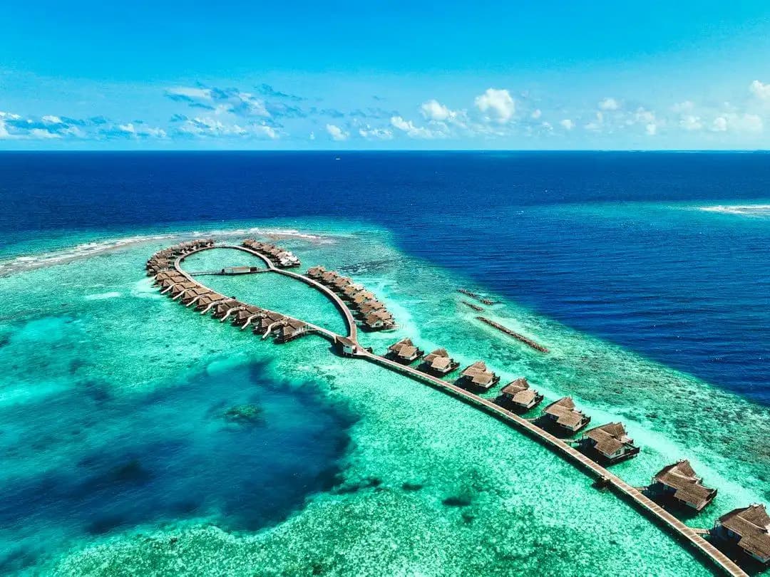 Wasserbungalows und türkisfarbene Lagune der Malediven aus der Luft