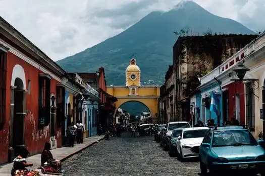 Street in Antigua Guatemala with the Santa Catalina Arch and a volcano behind