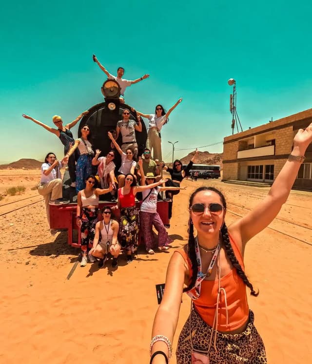 WeRoad travelers celebrating together in the Jordan desert during a group trip