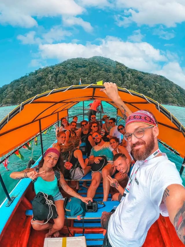 Gruppo di viaggiatori WeRoad si scatta un selfie su una longtail boat in Thailandia