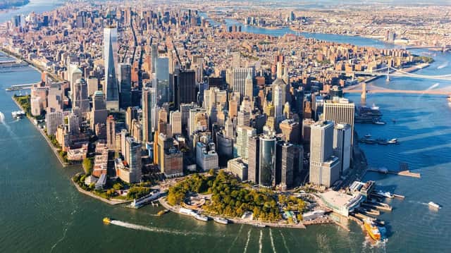 Luftaufnahme der Lower Manhattan Skyline an einem sonnigen Tag, mit dichten, von Flüssen umgebenen Wolkenkratzern.