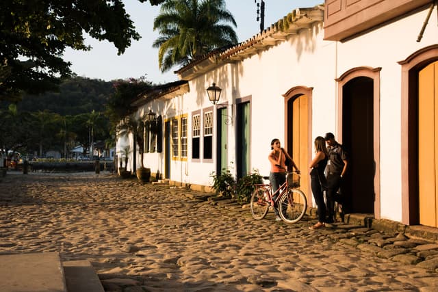 Calle empedrada de un pueblo colonial con casas blancas y puertas de colores.