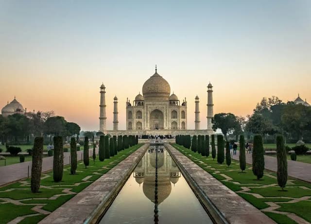 Taj Mahal at sunrise reflected in the long pool, India
