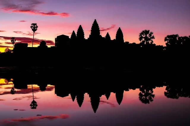 Sagoma dei templi di Angkor Wat al tramonto, riflessa nell'acqua, Cambogia