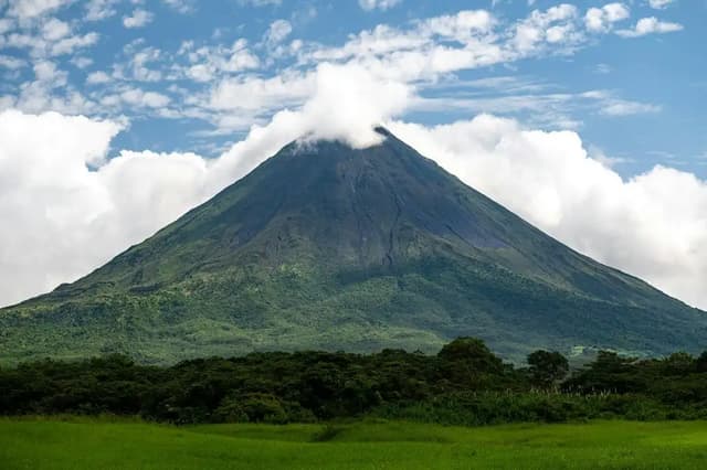 Volcano cone topped with clouds above the rainforest, Costa Rica